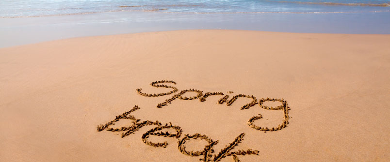"Spring Break" written in the sand on a beach
