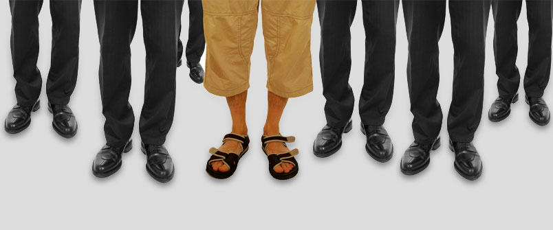 The legs of a bunch of well dressed people, and one person wearing capris and sandals