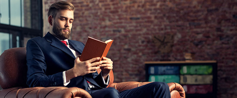 Well dressed man reading a book