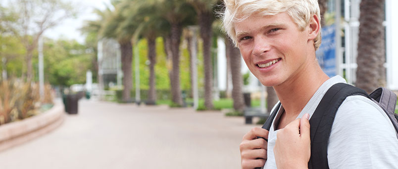 College student standing on campus with a backpack