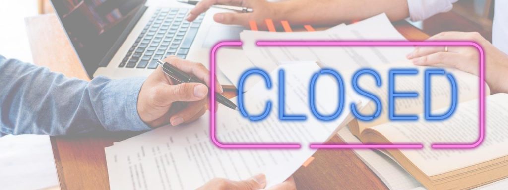 Neon closed sign overlayed on top of someone writing