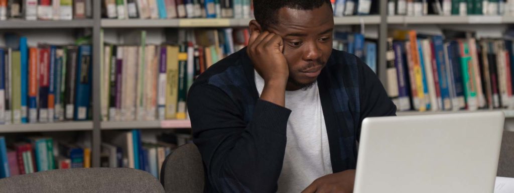 Unmotivated student sitting in front of a computer